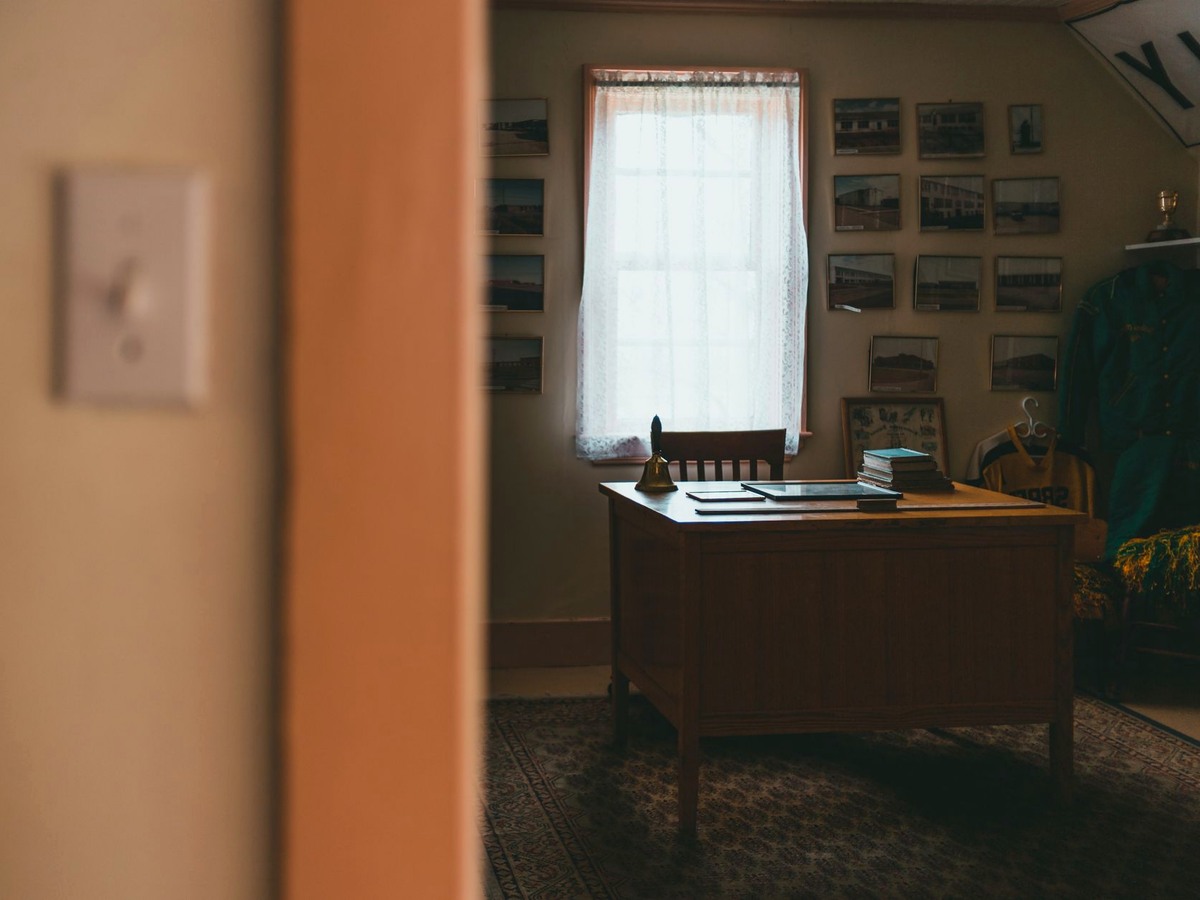 A welcome desk with linen, a coat rail and a plain photograph wall lit from two sides.