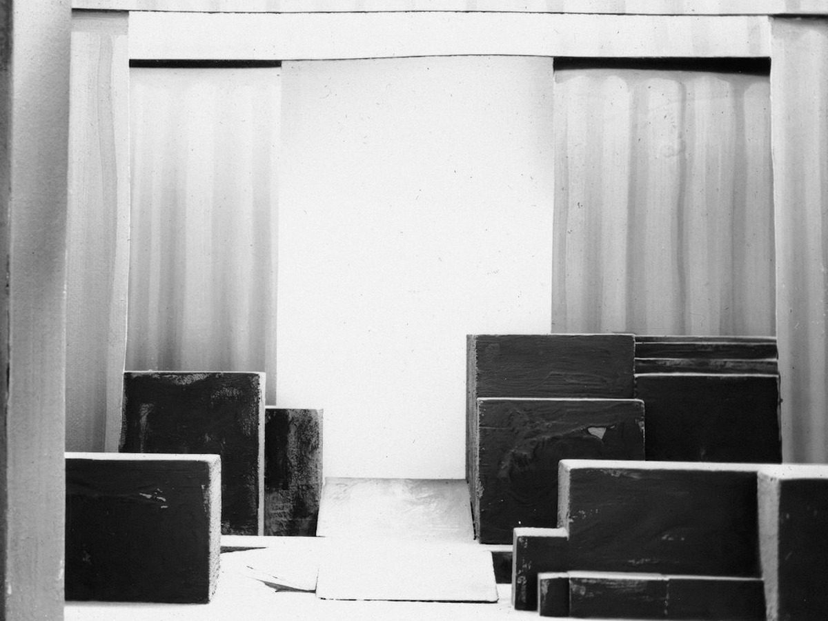 A laid dance floor in panels with a booth front and light stands at its edge, empty before doors.