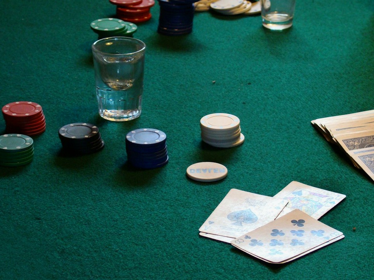 A green-cloth table with chip trays and a dealer shoe, photographed from the side before an evening starts.
