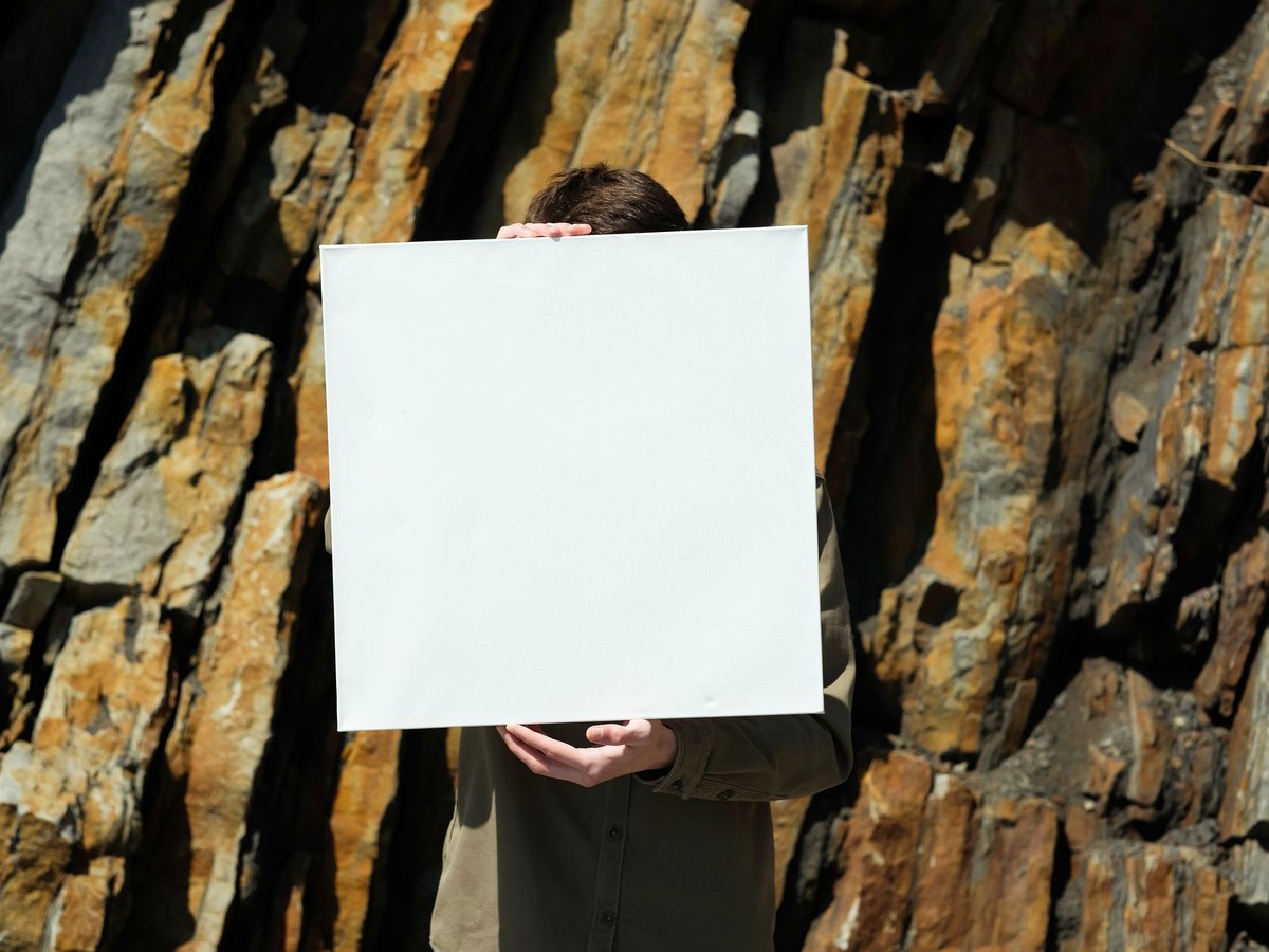 A clue board on a weighted stand on a stone quay, with a sealed pouch and pencil on the ground beside it.